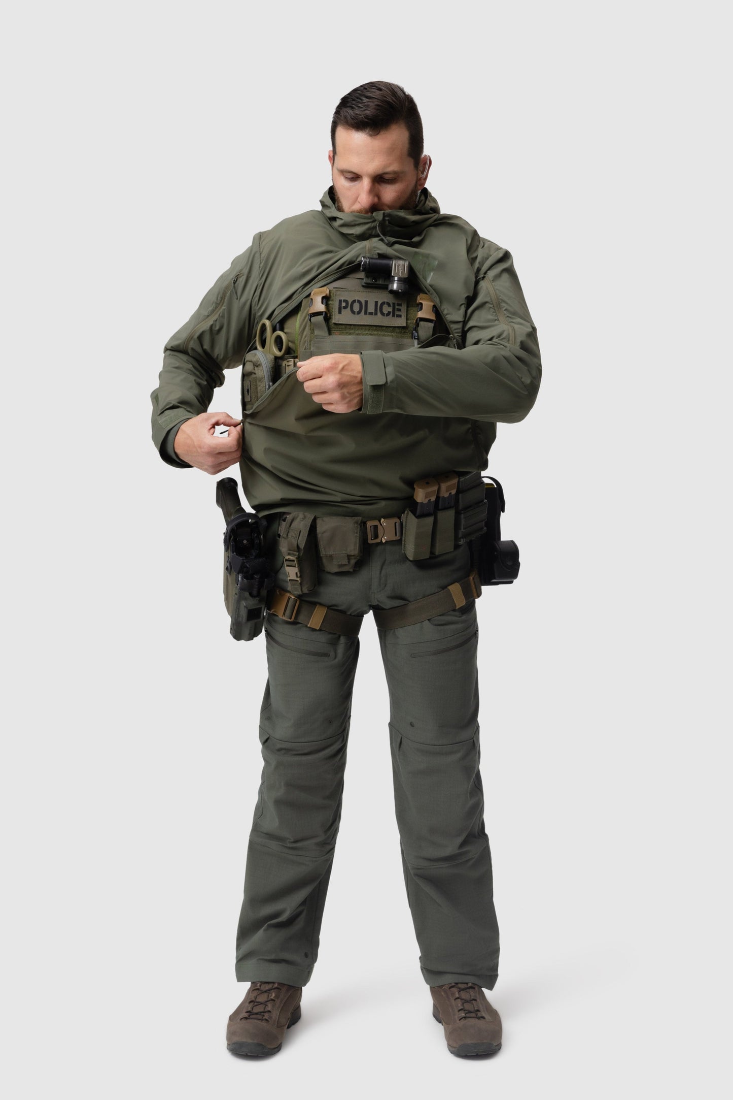 Frontal photo of the Tomahawk Performance Overlayer Anorak, tactical urban or military use weather protective layer, in the Ranger Green color way. Reverse-U zip shown being closed over a carrier.