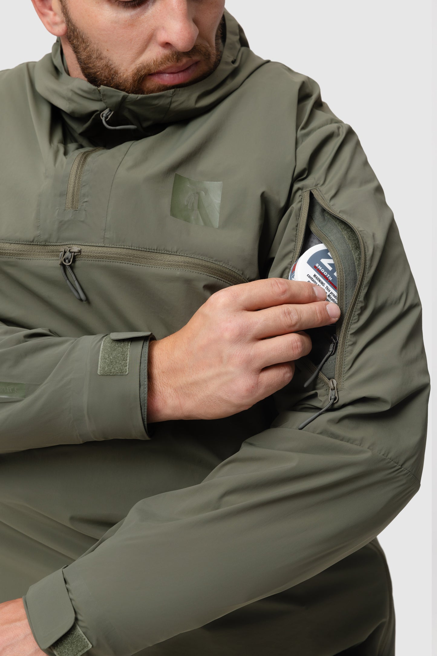 Close-up photo of the Tomahawk Performance Overlayer Anorak's vertical bicep zippered opening showing access to interior shoulder pockets.