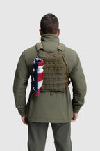 Back photo of the Tomahawk Performance Crosswind Jacket, a tactical windbreaker, worn under a carrier in Ranger Green color way.