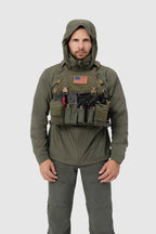 Frontal photo of the Tomahawk Performance Crosswind Jacket, a tactical windbreaker, worn under a carrier in Ranger Green color way.