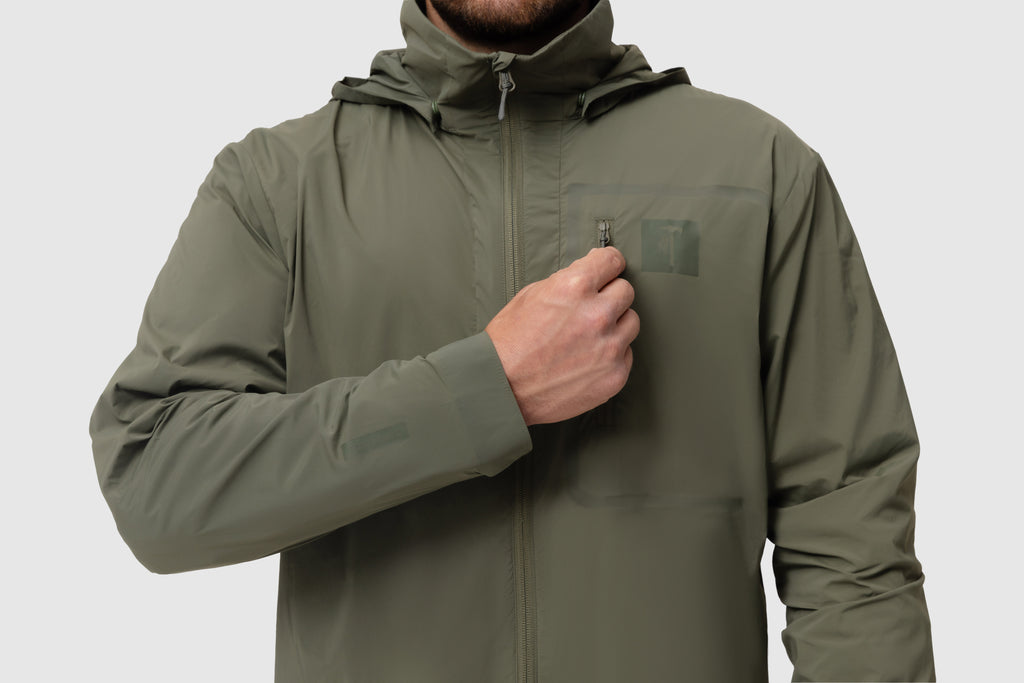 Front close-up photo of the Tomahawk Performance Crosswind Jacket, a tactical windbreaker, depicting the chest pocket and attachment point in Ranger Green color way.
