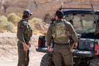 Two men wearing the Tomahawk Performance HW / Combat Uniform loading gear out of a side-by-side vehicle.